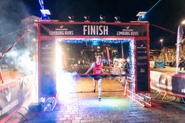 De winnaar van de Santa Run 2024 die over de finish komt