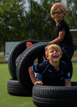 Kinderen spelen in een obstakel van autobanden